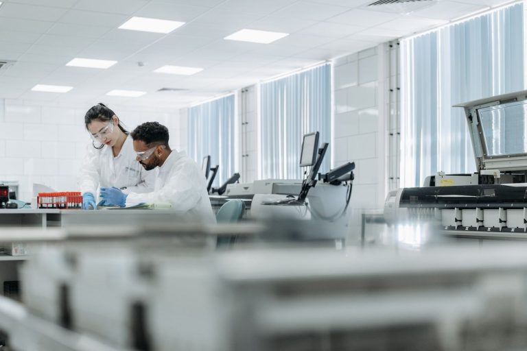 CNPq amplia chamada científica latino-americana com recursos adicionais e projetos de IA Dois cientistas colaboram em um laboratório equipado, usando óculos de proteção e luvas durante uma atividade de pesquisa.